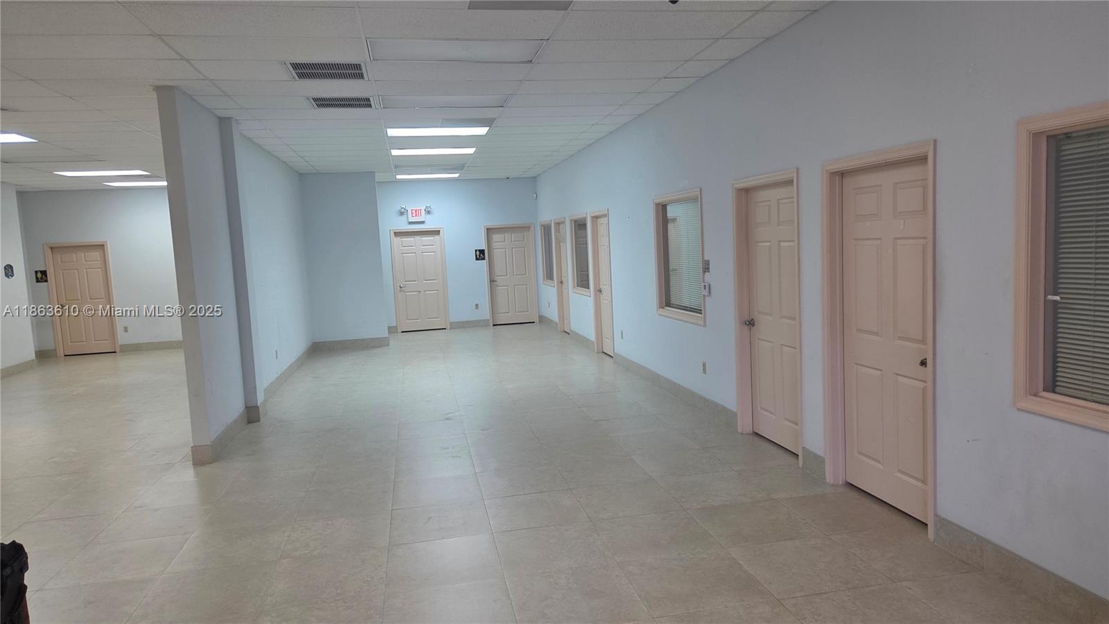 An office hallway features light-colored tile flooring, multiple doors, and a drop ceiling — 1150 SW 30th Ave, Pompano Beach FL 33069, POMPANO BEACH, FL