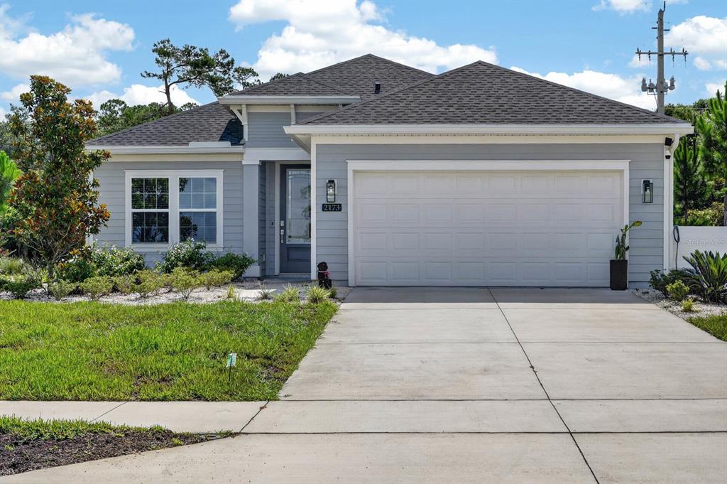 A single-story house with light gray siding, a two-car garage, and a concrete driveway — 2173 RAGLAN CIRCLE, ORMOND BEACH, FL