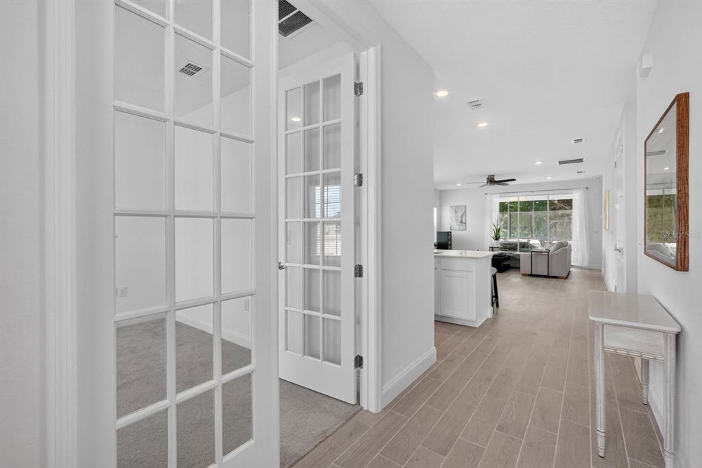 A hallway with tile flooring leads to an open-concept kitchen and living area — 2173 RAGLAN CIRCLE, ORMOND BEACH, FL