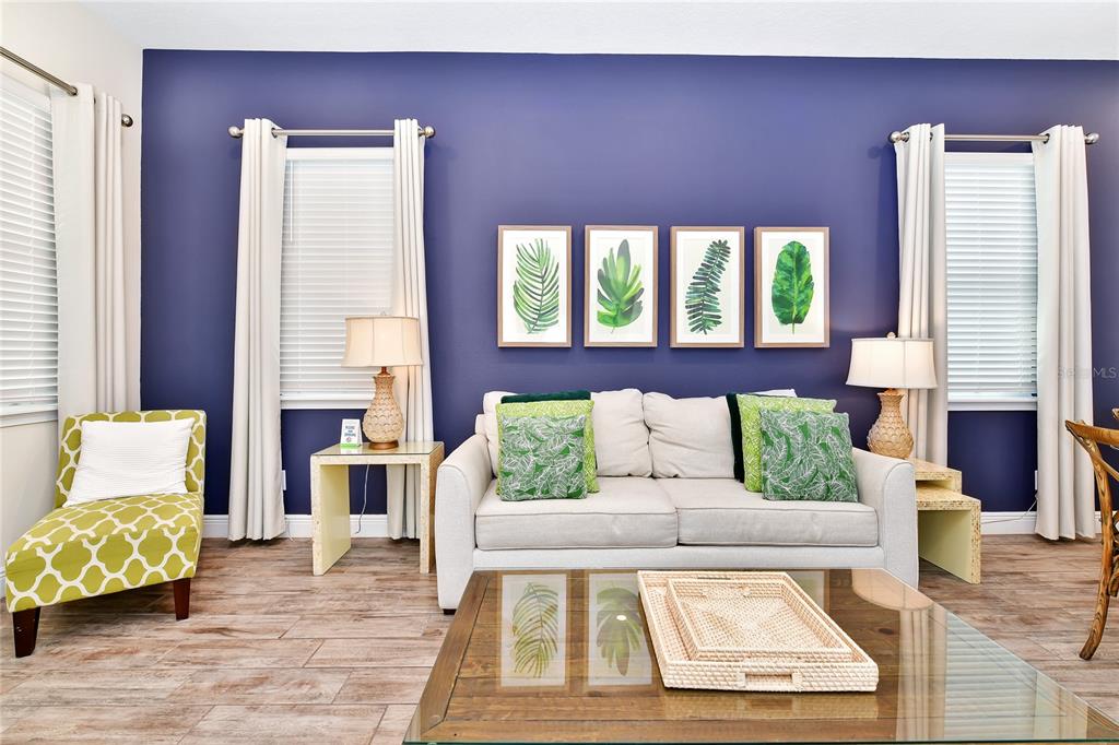 A living room features a patterned green chair, a side table with a lamp, and sofa — 8048 DREAMSICLE DRIVE, KISSIMMEE, FL