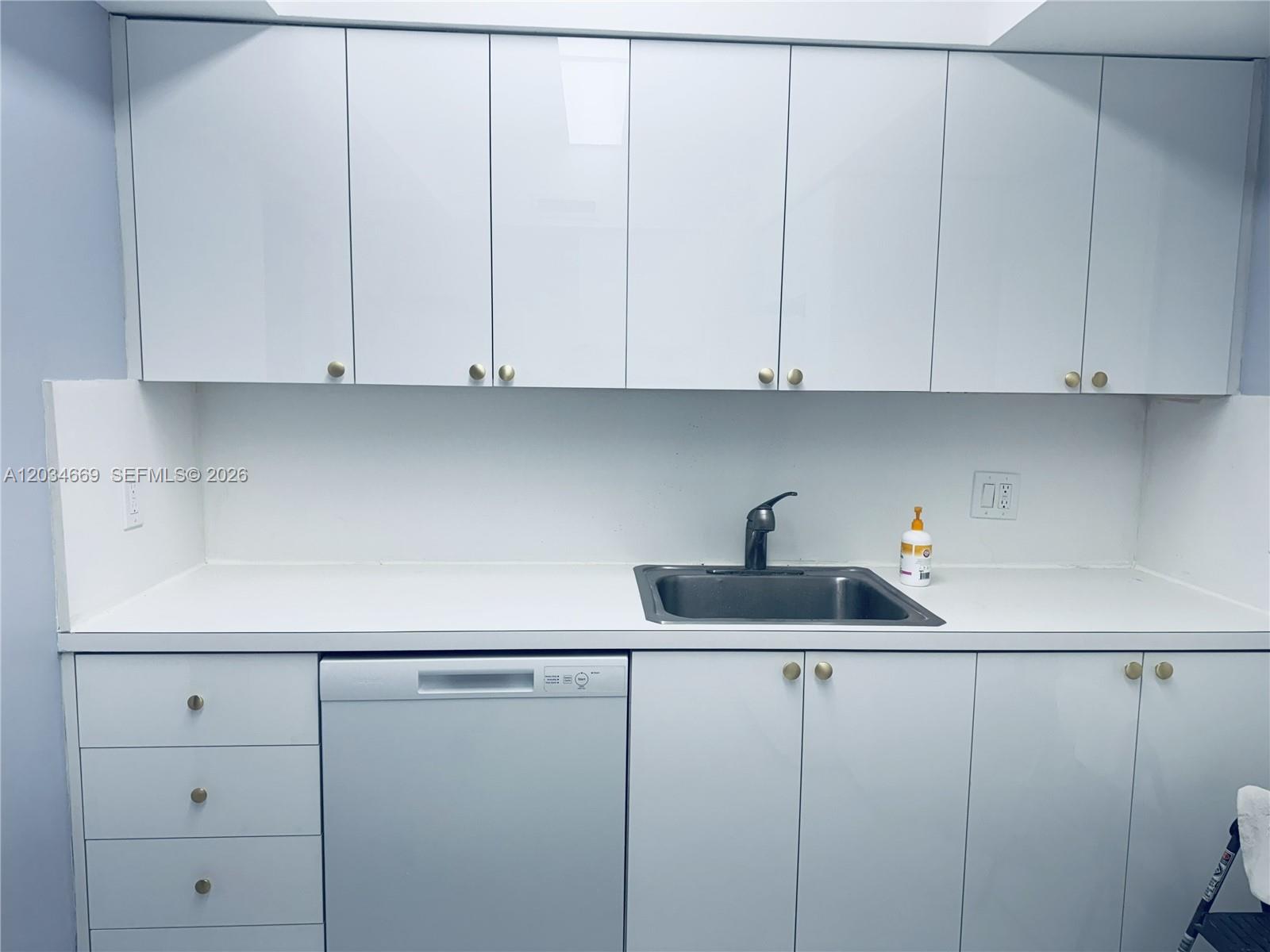 A kitchen features white flat-panel cabinets, a stainless steel sink, and a built-in dishwasher — 3505 S Ocean Dr # 704, Hollywood FL 33019, HOLLYWOOD, FL