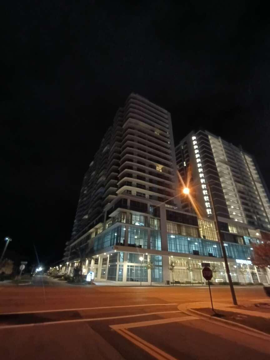 A low-angle night view of a modern high-rise apartment building with glass balconies — 220 Lake Shore Drive # 823, FL 33403, FL