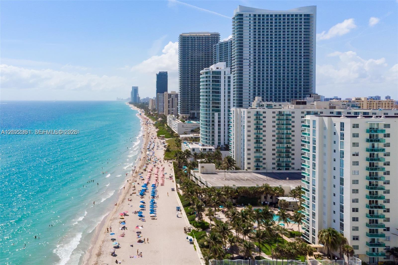 An aerial view of a sandy beach lined with high-rise buildings and palm trees — 3801 S Ocean Dr # 2Z, Hollywood FL 33019, HOLLYWOOD, FL