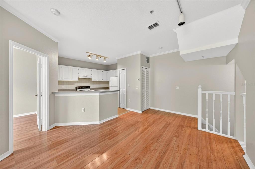 An interior view shows a kitchen with white cabinets and a breakfast bar overlooking a living area — 2847 SHADOW VIEW CIRCLE UNIT 2847, MAITLAND, FL
