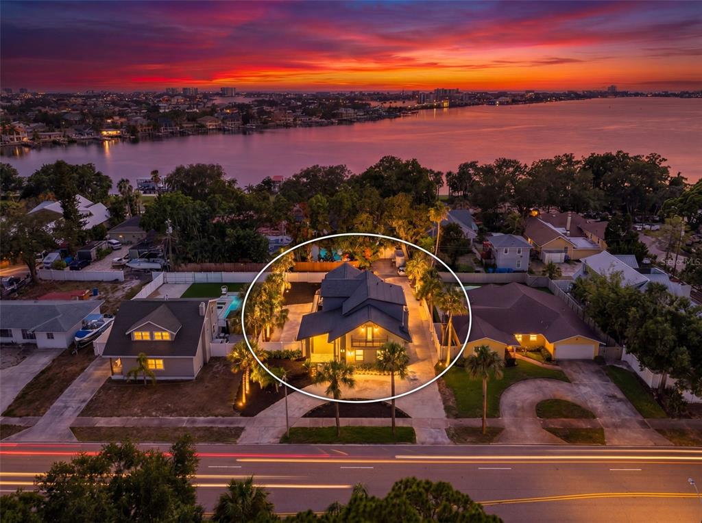 An aerial view of a house at dusk with a sunset over the water behind — 310 PARK STREET N, ST PETERSBURG, FL