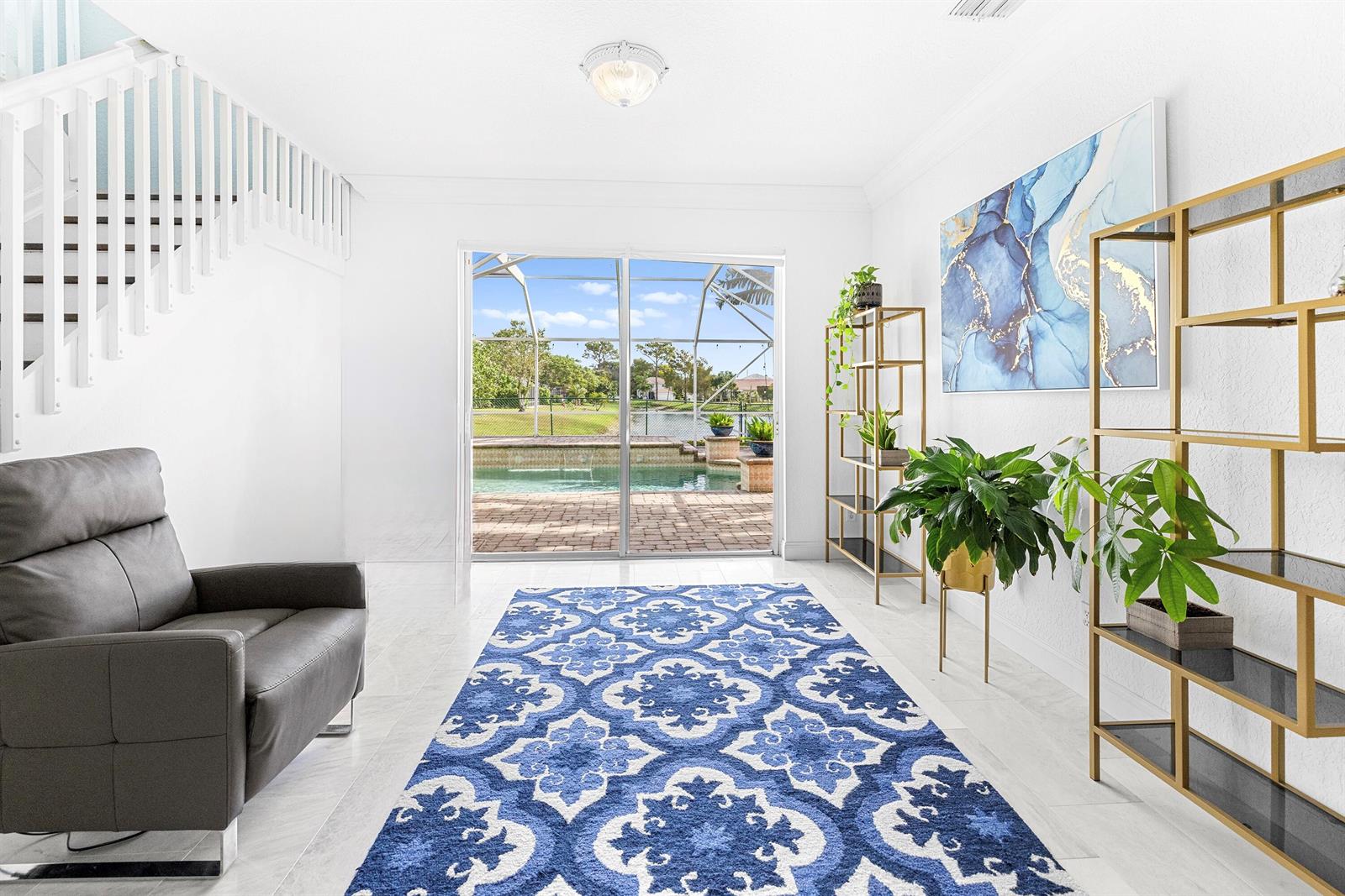 A bright room features a blue patterned rug, a leather chair, and sliding glass doors — 6575 Spring Meadow Drive, FL 33413, FL