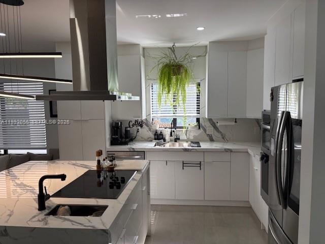 A modern kitchen features white cabinetry, marble countertops, a large island, and stainless steel appliances — 111 NW 46th St, Miami FL 33127, MIAMI, FL