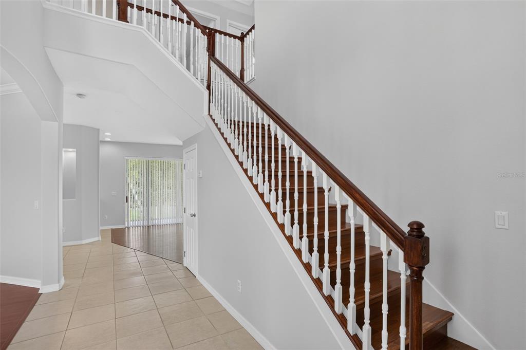 A staircase with wooden treads and white railings leads to an upper landing — 2521 BARWICK STREET, ORLANDO, FL