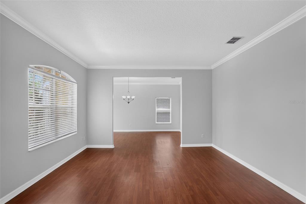 An empty room with gray walls, dark wood flooring, and an arched window — 2521 BARWICK STREET, ORLANDO, FL