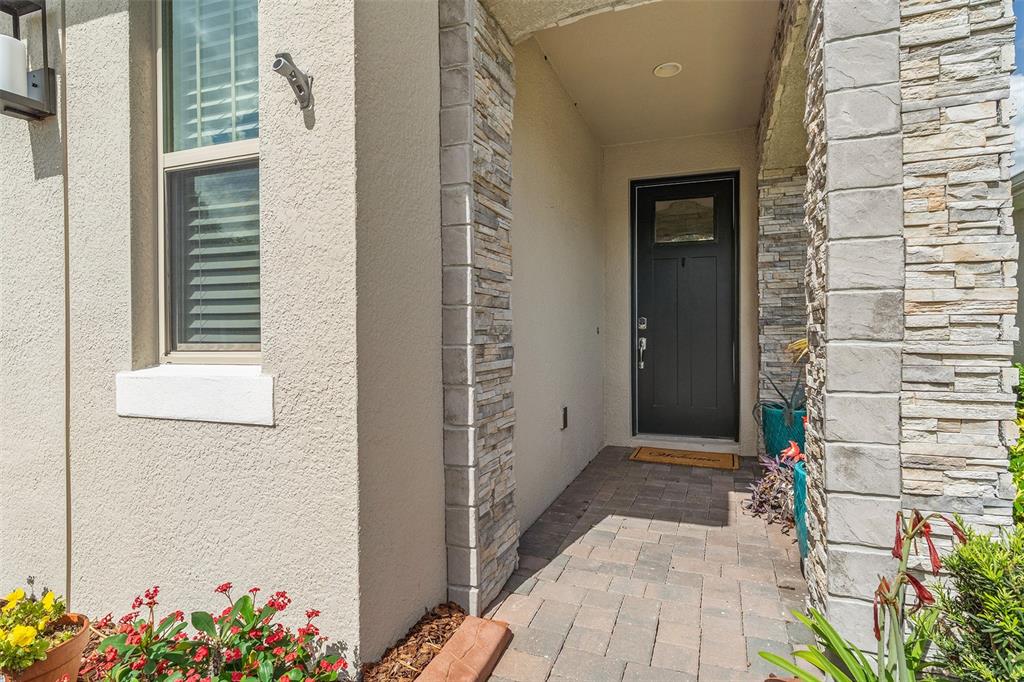 A front entryway features a dark door, stone-accented columns, and a paved walkway — 3113 SONGBIRD CIR, ST CLOUD, FL