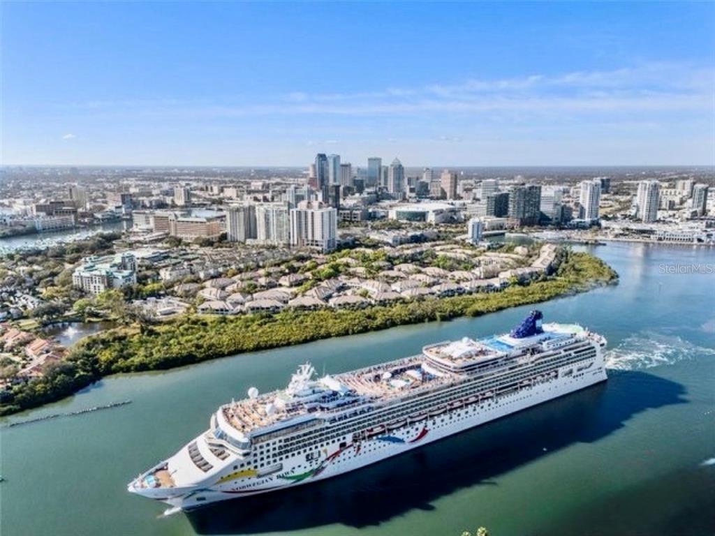 An aerial view of a cruise ship sailing on a river near a city skyline — 724 CORAL REEF DRIVE, TAMPA, FL