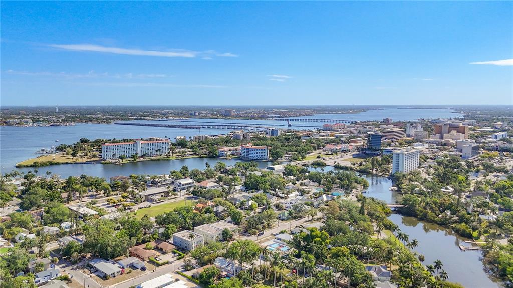 An aerial view shows a coastal city with buildings, a river, and a long bridge — 2006 7TH AVENUE W UNIT B, BRADENTON, FL
