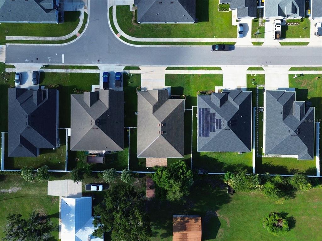 An aerial view shows a row of suburban houses with driveways and backyards — 6864 MOSSY OAK LANE, LAKELAND, FL