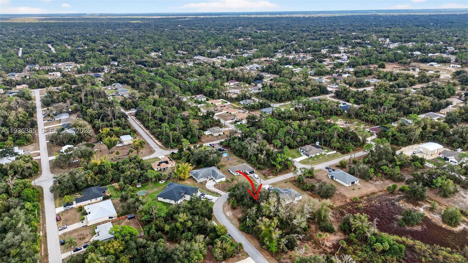 An aerial view shows a residential neighborhood with houses surrounded by trees and vegetation — 0 NELL RD, North Port FL 34288, NORTH PORT, FL