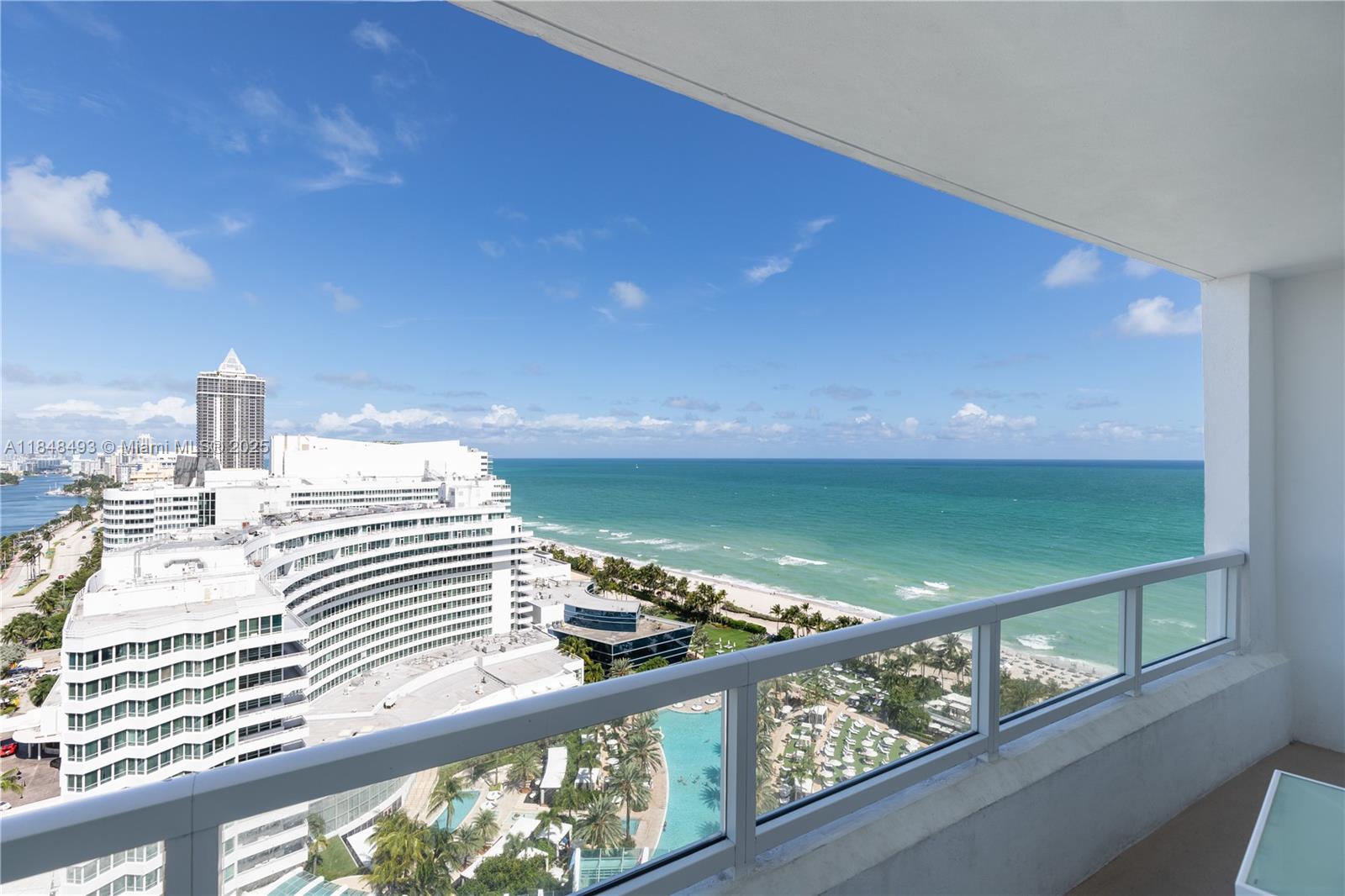 A balcony view overlooks a large hotel complex, a swimming pool, and the ocean — 4391 Collins Ave # 1605, Miami Beach FL 33140, MIAMI BEACH, FL