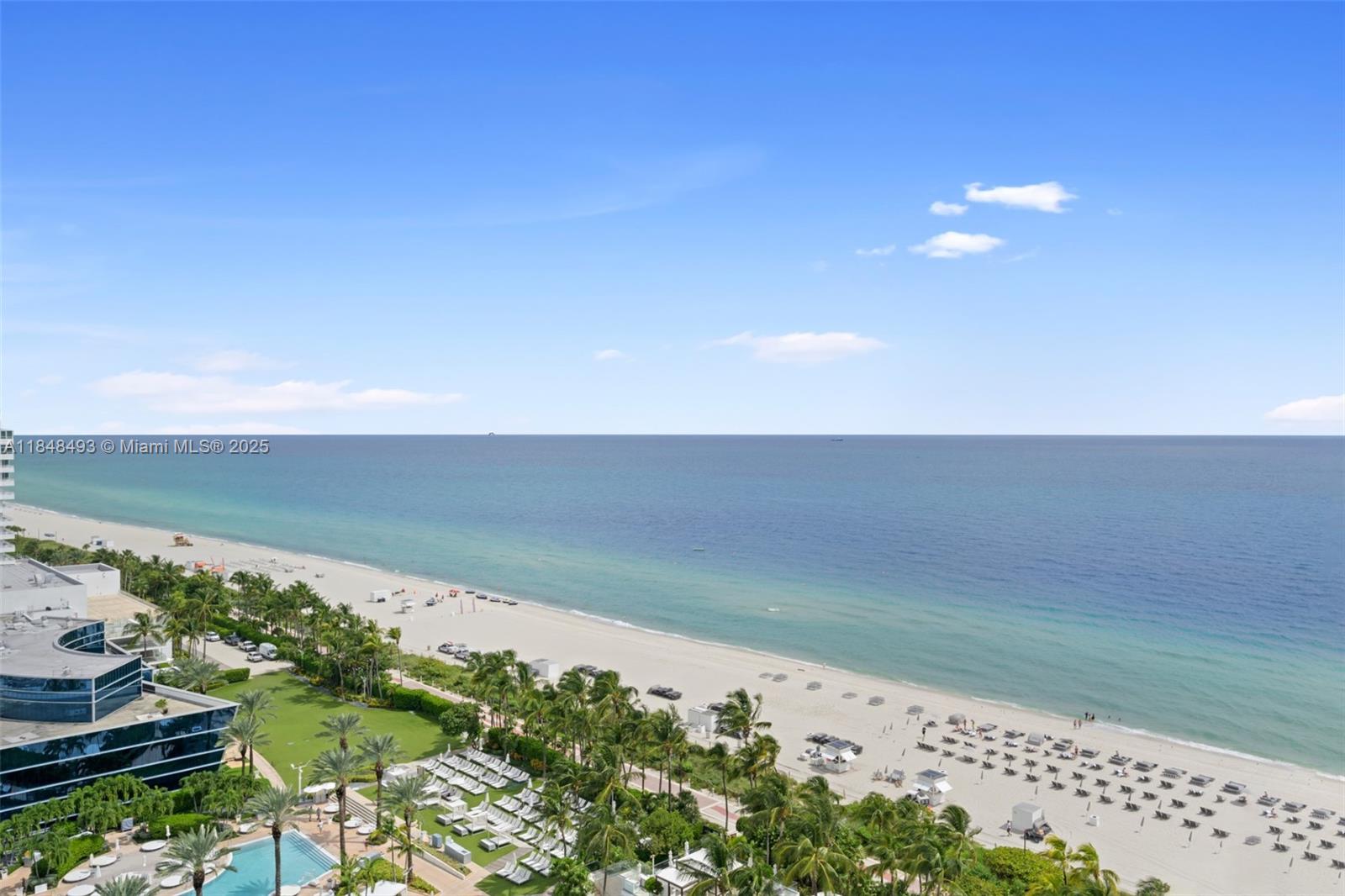 An elevated view of a sandy beach, ocean, and palm trees from a high-rise balcony — 4391 Collins Ave # 1605, Miami Beach FL 33140, MIAMI BEACH, FL