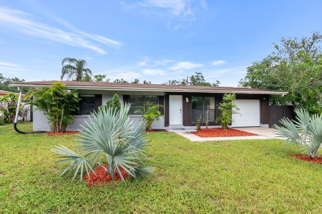 A living room with terrazzo floors, a ceiling fan, and a view into a sunroom — 8709 N RENFREW PLACE, TAMPA, FL