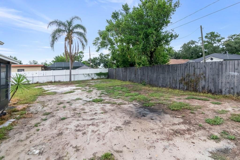 A kitchen features grey cabinets, stainless steel appliances, white countertops, and white tile flooring — 8709 N RENFREW PLACE, TAMPA, FL