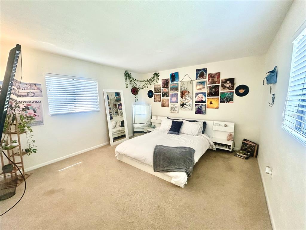 A living room features a brown sectional sofa, a television on a stand, and tile flooring — 407 NW 39TH RD UNIT 407C, GAINESVILLE, FL