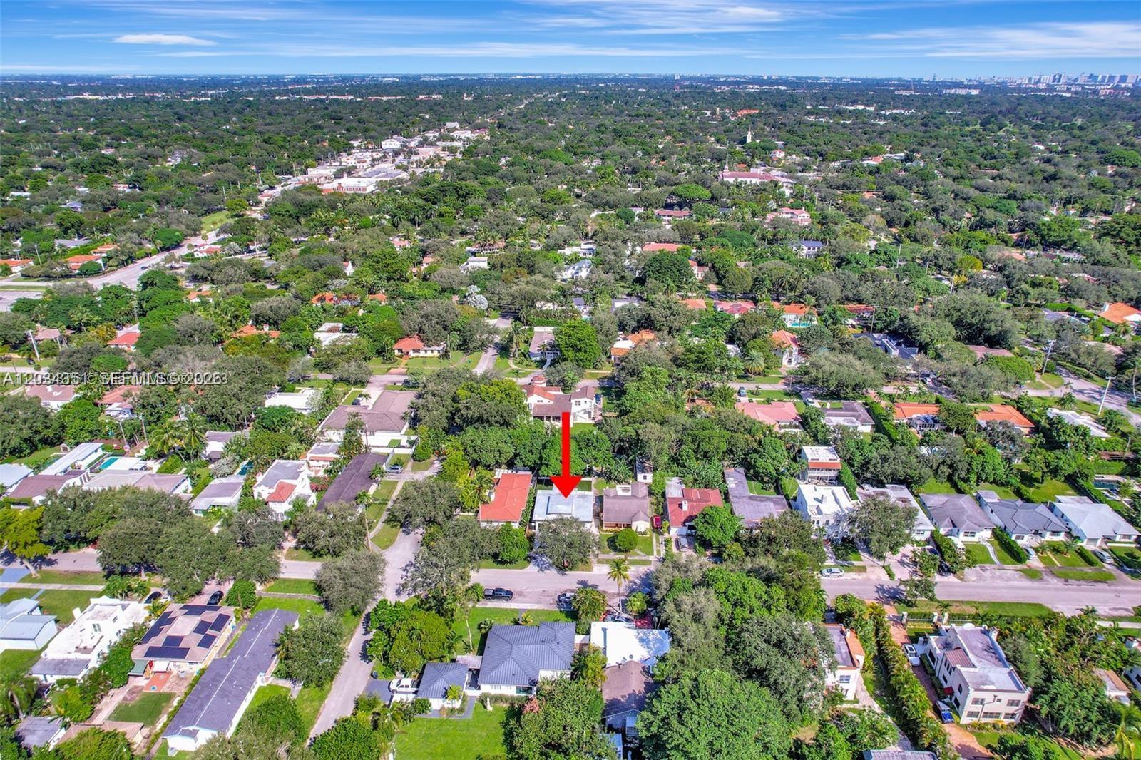 An aerial view shows a residential neighborhood with a red arrow pointing to a house — EL PORTAL, FL