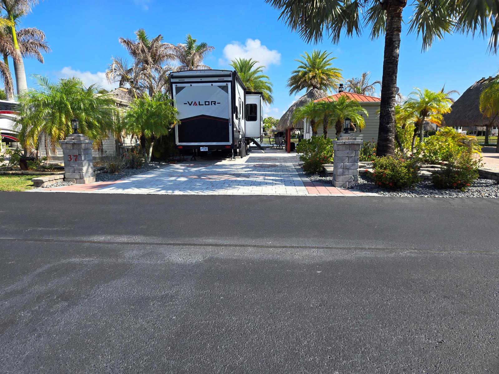 A recreational vehicle is parked on a paved driveway in front of a small building — 609 SW 42nd Cove, Okeechobee FL 34974, OKEECHOBEE, FL