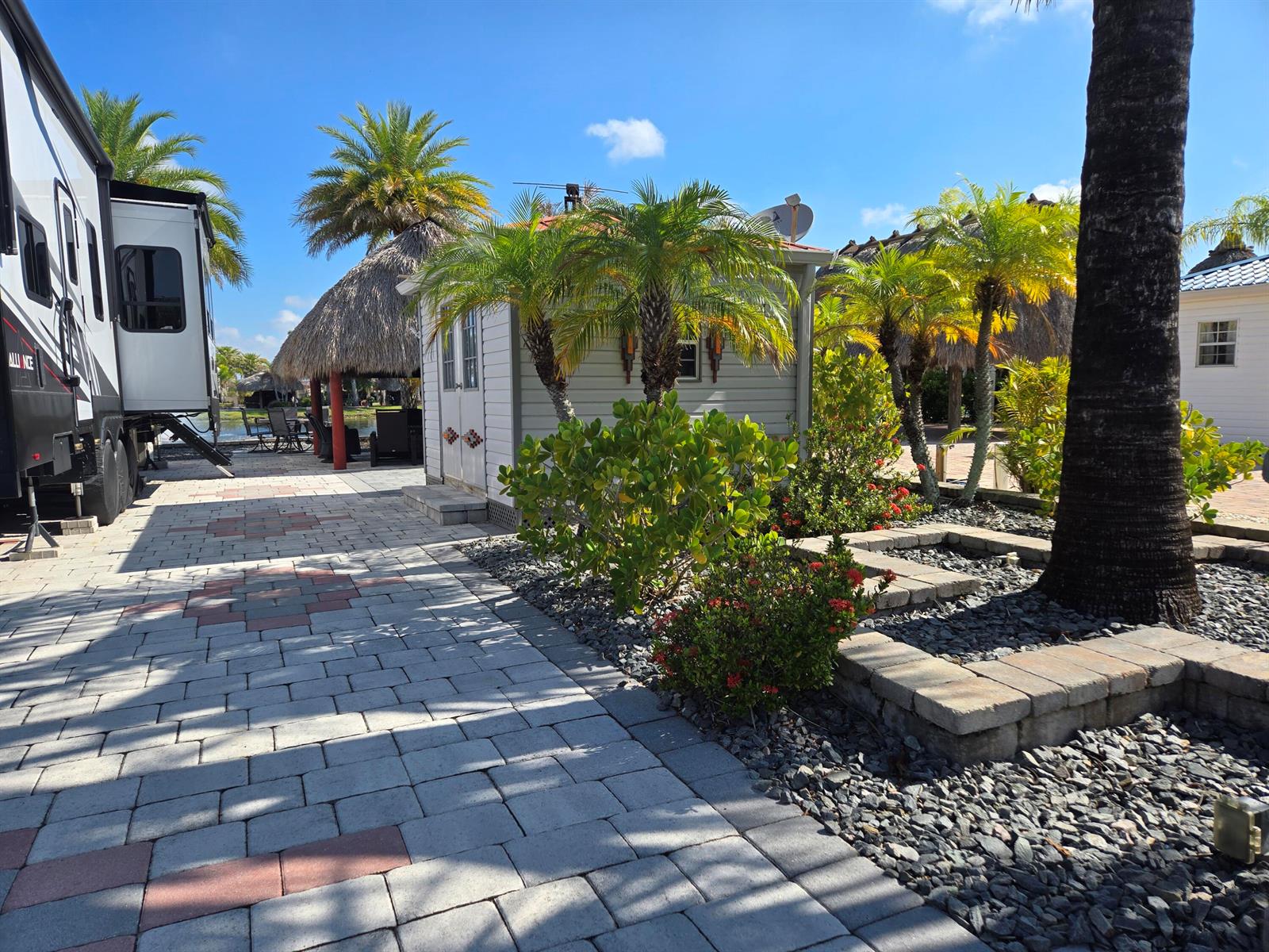 A paved patio area features a small shed, palm trees, and a parked recreational vehicle — 609 SW 42nd Cove, Okeechobee FL 34974, OKEECHOBEE, FL
