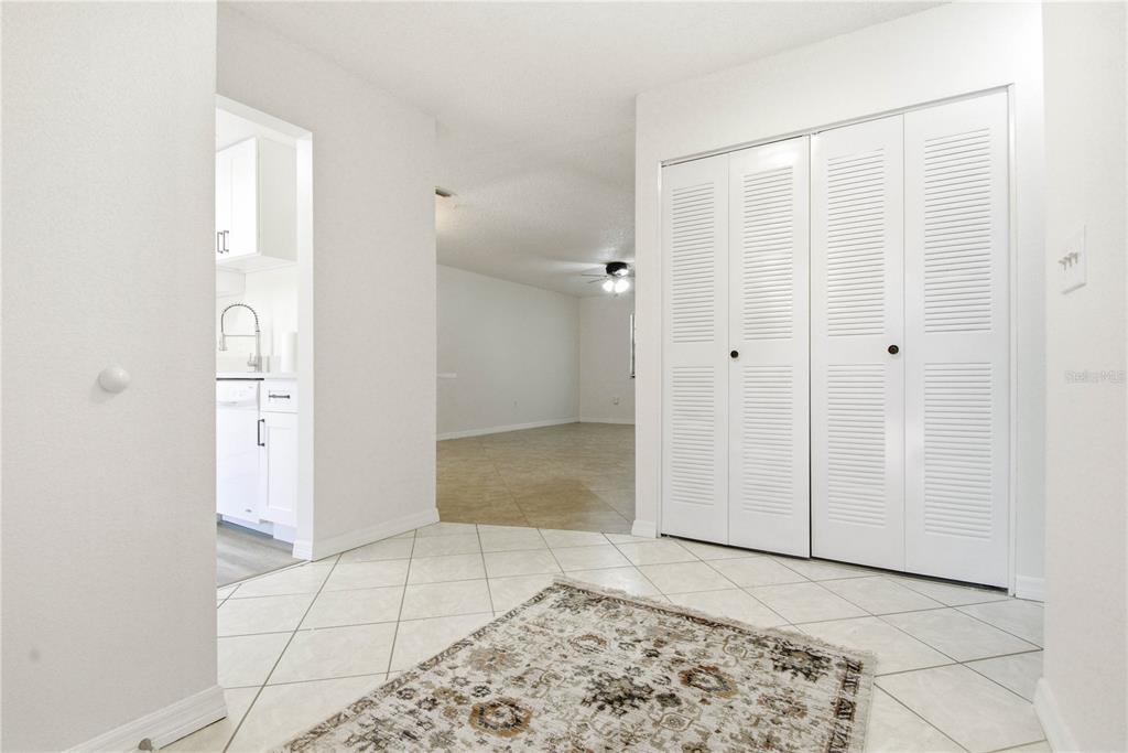A tiled entryway leads to a living area with a closet and a kitchen view — 2909 FIG COURT, PALM HARBOR, FL