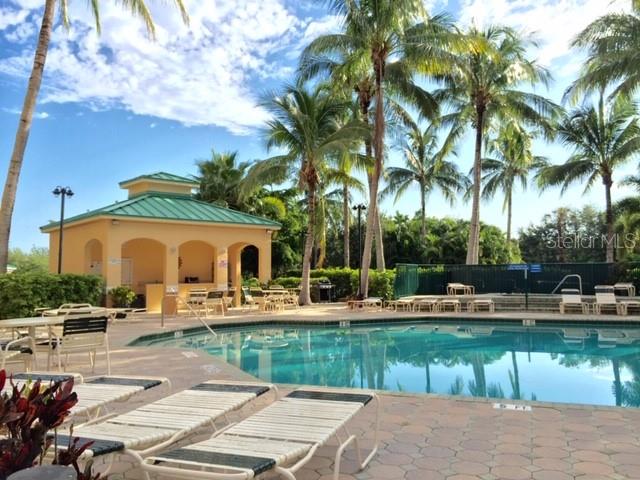 A swimming pool with lounge chairs and a covered pavilion surrounded by palm trees — 2060 MATECUMBE KEY ROAD UNIT 2105, PUNTA GORDA, FL