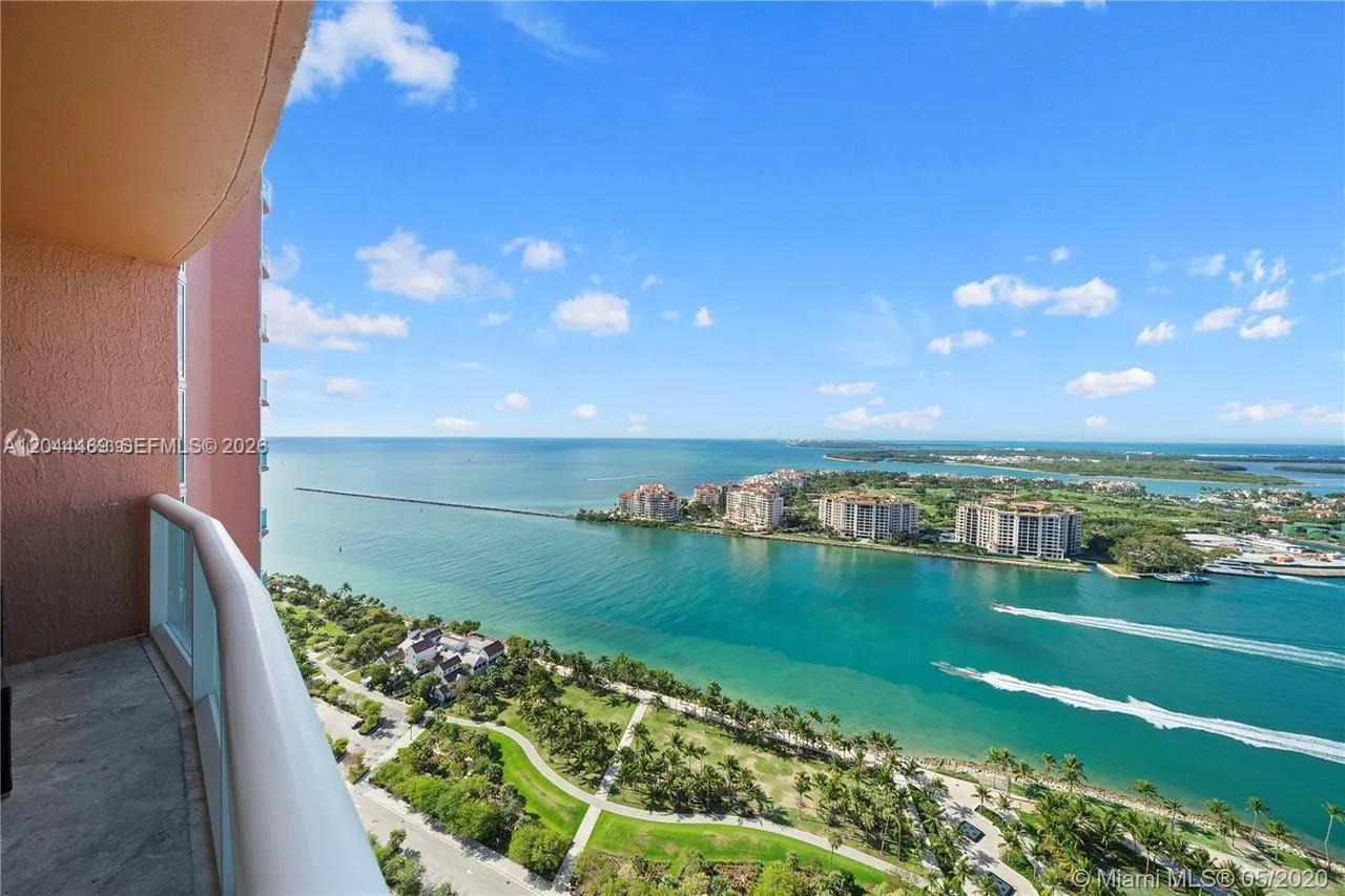 A high-angle view from a balcony overlooking a bay, park, and coastal buildings — 300 S Pointe Dr # 3604, Miami Beach FL 33139, MIAMI BEACH, FL