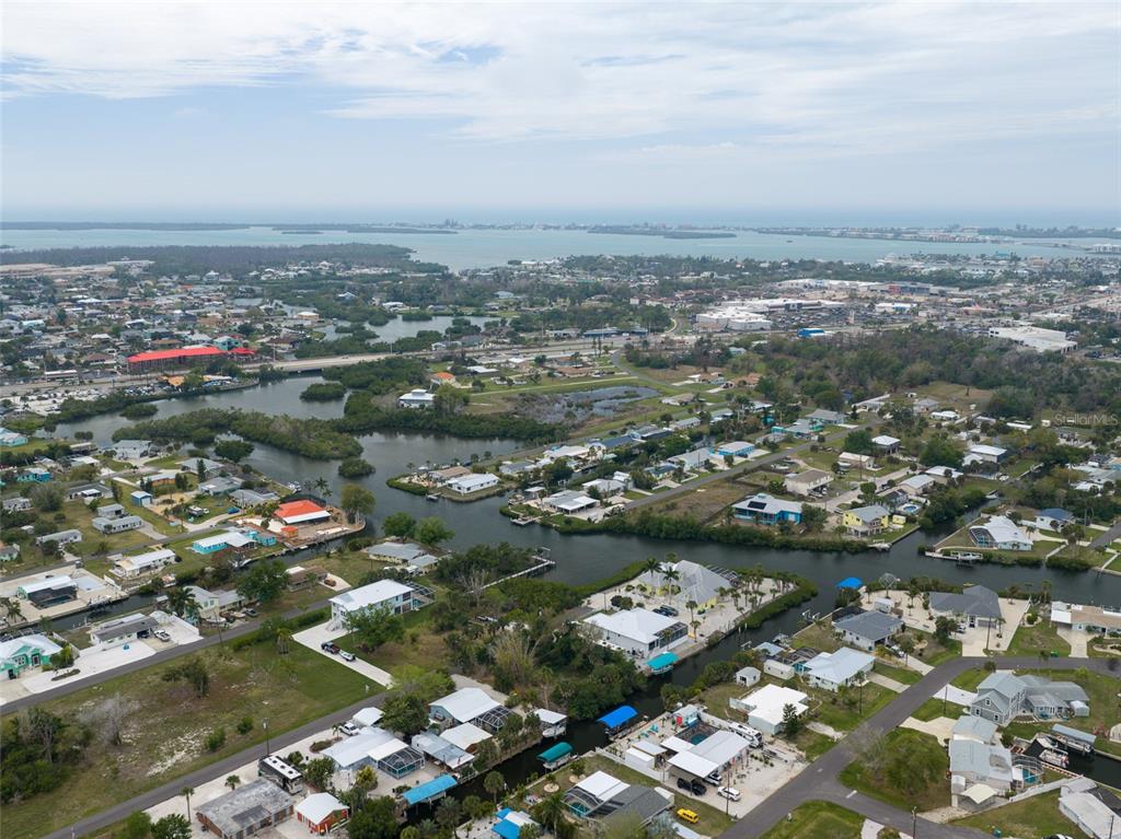 An aerial view shows a coastal neighborhood with houses situated along winding canals and mangroves — 1132 ANDREWS STREET, ENGLEWOOD, FL