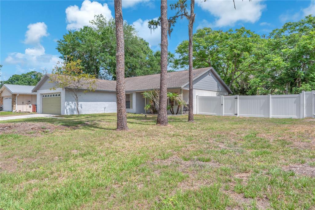 A single-story house with a white brick exterior, a garage, and a white privacy fence — 3619 ORANGEPOINTE ROAD, VALRICO, FL