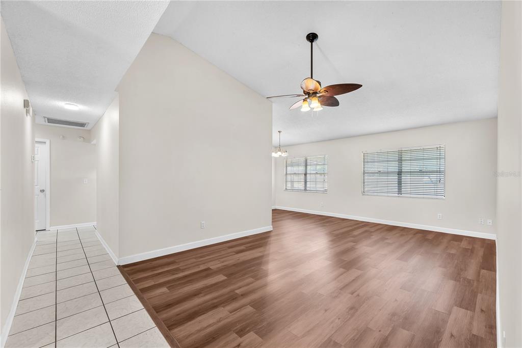 A living room with wood-look flooring, a vaulted ceiling, and a ceiling fan — 3619 ORANGEPOINTE ROAD, VALRICO, FL
