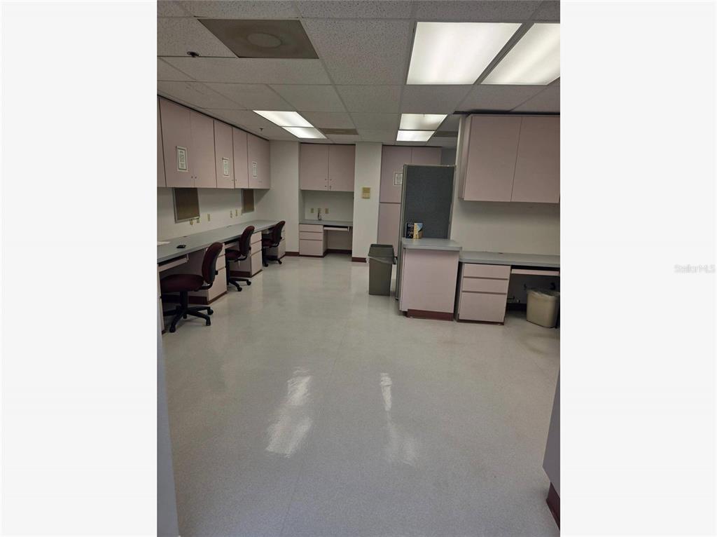 An office or laboratory space featuring light-colored cabinetry, laminate countertops, and a drop ceiling — 2525 HARBOR BOULEVARD UNIT 101, PORT CHARLOTTE, FL