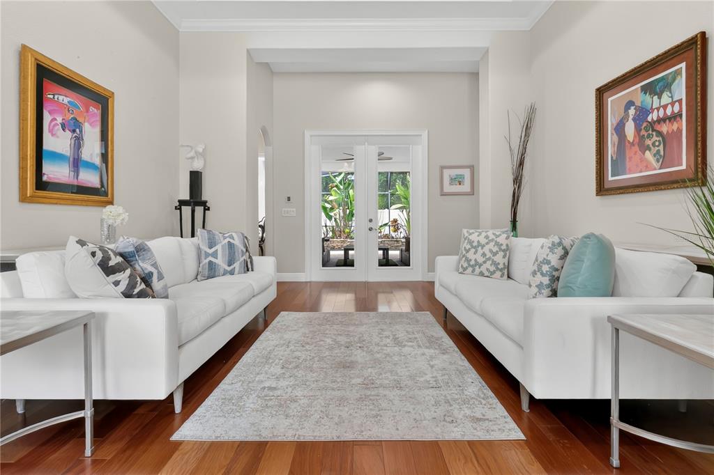 A living room features two white sofas facing each other on a rug over wood floors — 6361 BORDEAUX CIRCLE, SANFORD, FL
