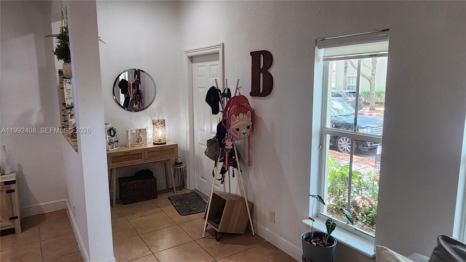 An entryway features a console table, a coat rack with a backpack, and a window — 2607 SW 99th Way, Miramar FL 33025, MIRAMAR, FL