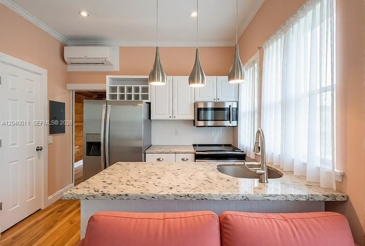A kitchen features white cabinets, stainless steel appliances, a granite island, and pendant lighting — 1411 Truman Ave # 0, Key West FL 33040, KEY WEST, FL