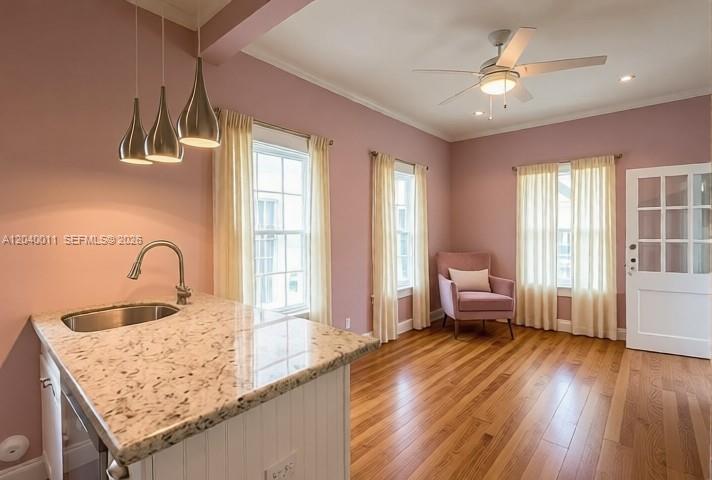 A kitchen island with a granite countertop sits in a room with pink walls — 1411 Truman Ave # 0, Key West FL 33040, KEY WEST, FL