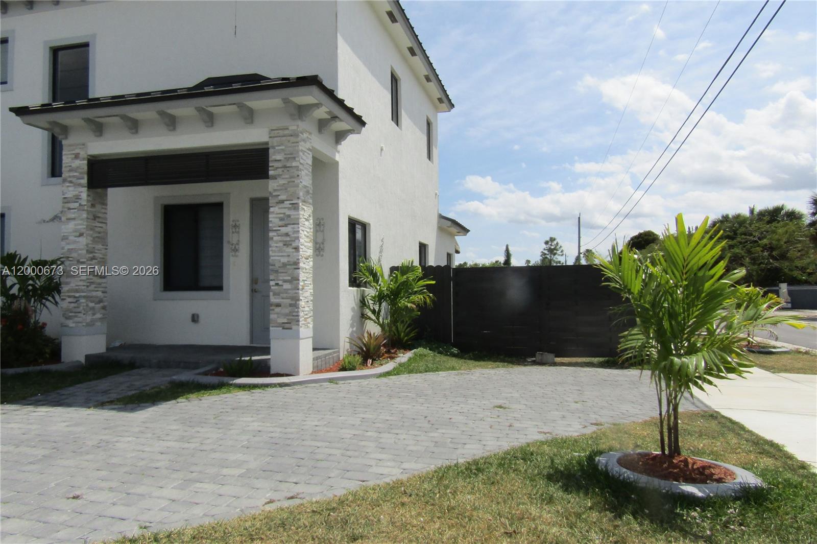 A two-story white house features a stone-accented front porch and a paved driveway — 11998 SW 232nd St, Miami FL 33170, MIAMI, FL