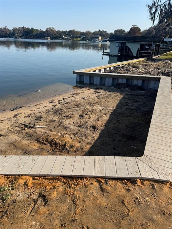 A newly constructed composite bulkhead and deck overlook a lake with a nearby boat house — 1232 CR 17 ROAD N, LAKE PLACID, FL