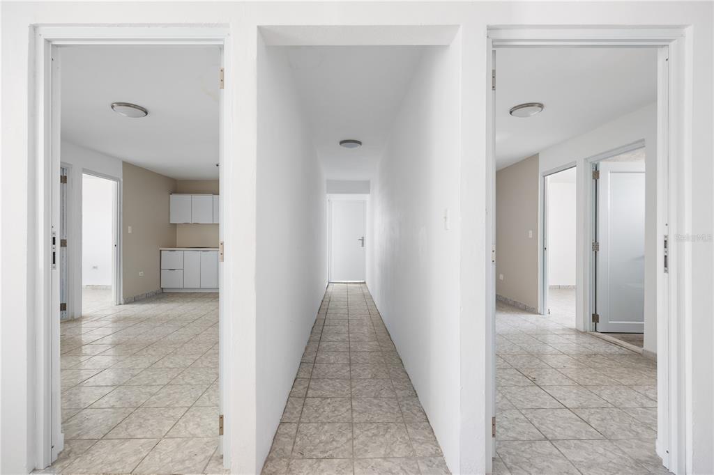 A central hallway leads to a back door, flanked by two rooms with tiled floors — 21 EDUARDO CONDE, SAN JUAN, PR