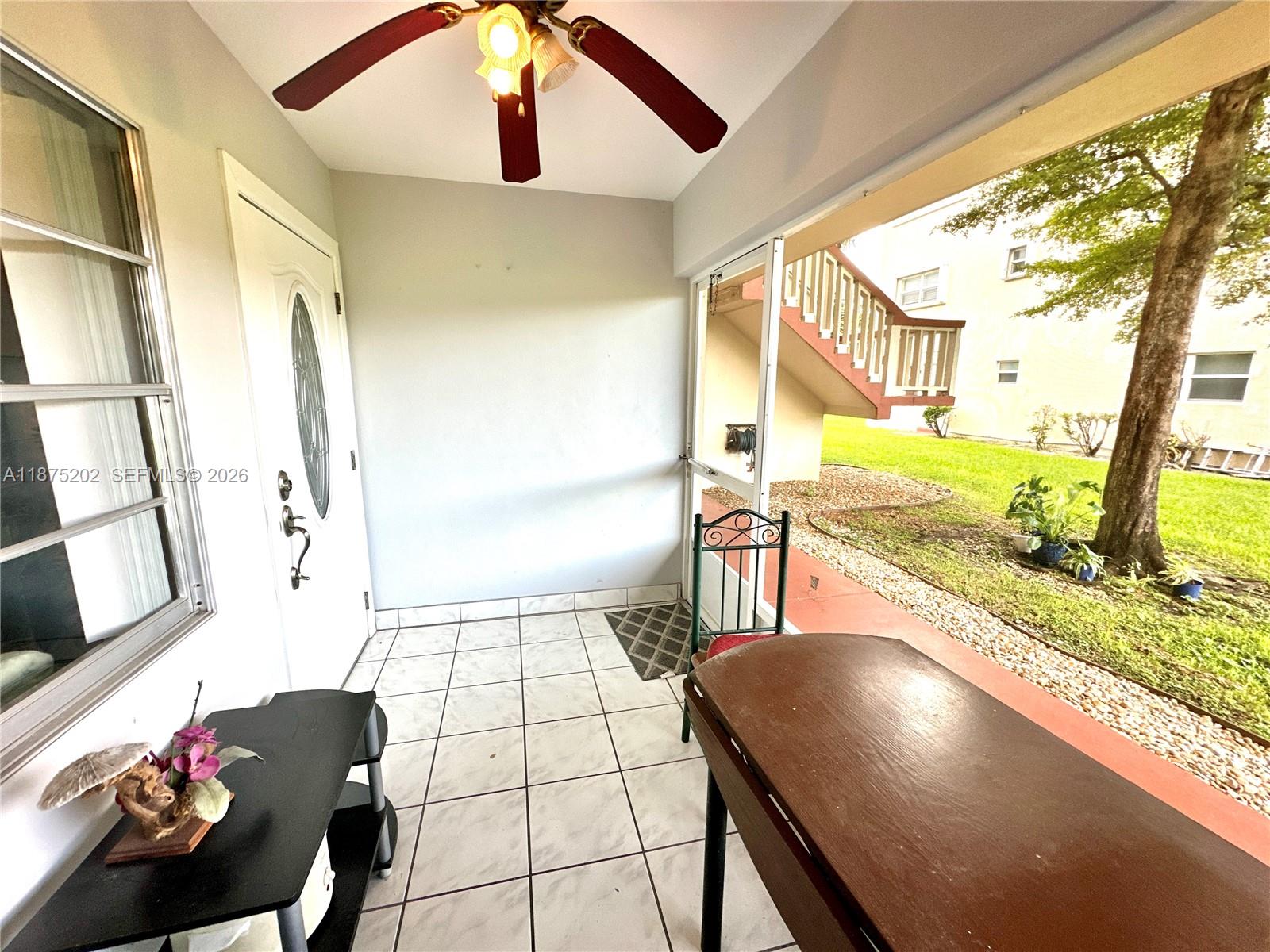 A covered patio features white tile flooring, a ceiling fan, and a view of grass — 5300 Washington St # A139, Hollywood FL 33021, HOLLYWOOD, FL