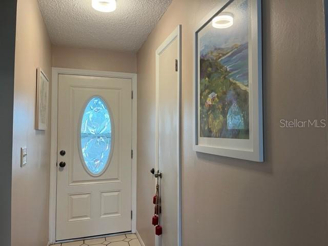 An entryway features a white front door with an oval window and framed wall art — 9616 MIDIRON COURT, NEW PORT RICHEY, FL