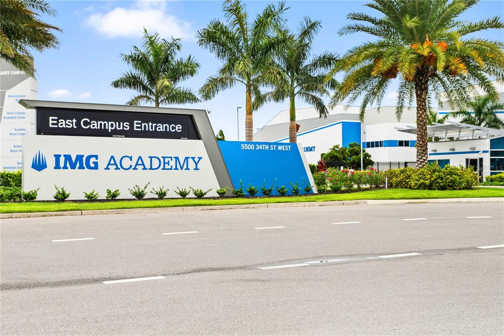 The entrance sign for IMG Academy stands beside a road with palm trees behind it — 3506 54TH DRIVE W UNIT 108, BRADENTON, FL