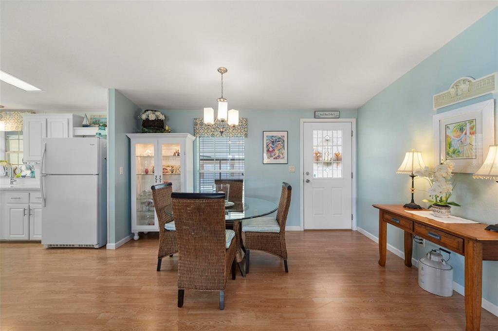 A dining area with a glass table, wicker chairs, and a white hutch on light flooring — 1000 KINGS HIGHWAY UNIT 487, PORT CHARLOTTE, FL