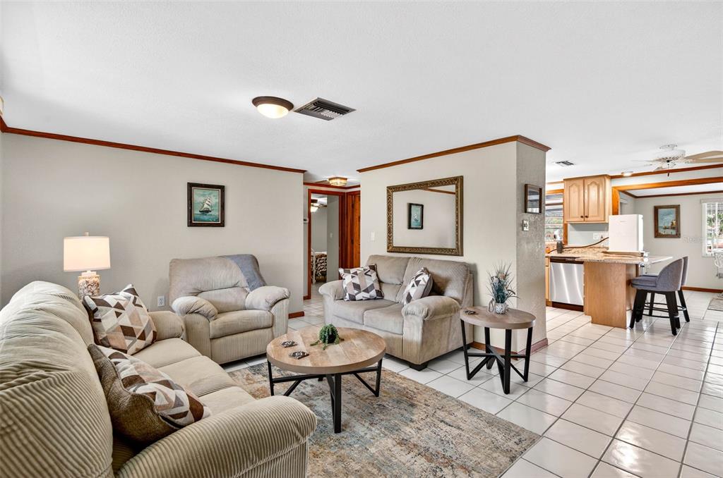 A living room with beige furniture, a round coffee table, and tile flooring — 6645 HARBOR DRIVE, HUDSON, FL