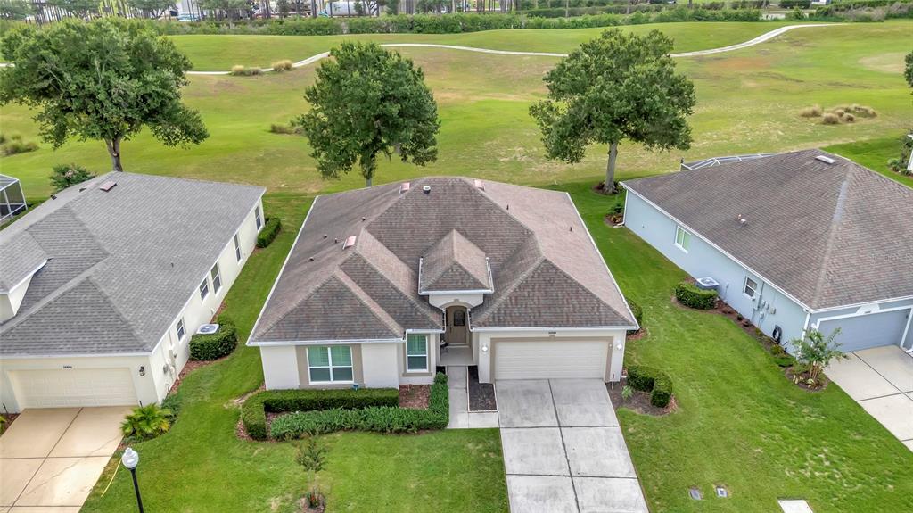 An aerial view shows a single-story house with a brown roof situated between two neighbors — 3551 CHESSINGTON STREET, CLERMONT, FL