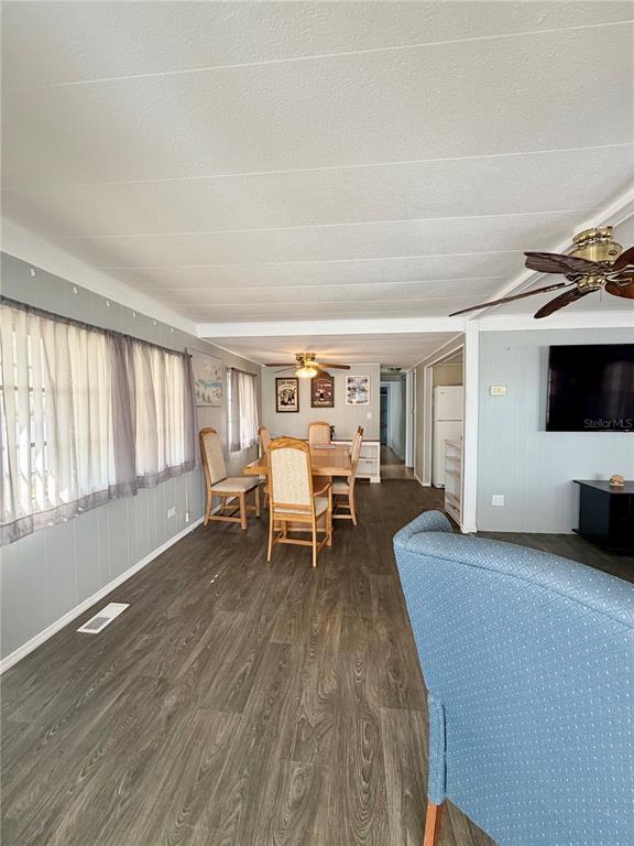 A dining area with a wooden table and chairs sits between a living room and kitchen — 10399 67TH AVENUE UNIT 4, SEMINOLE, FL