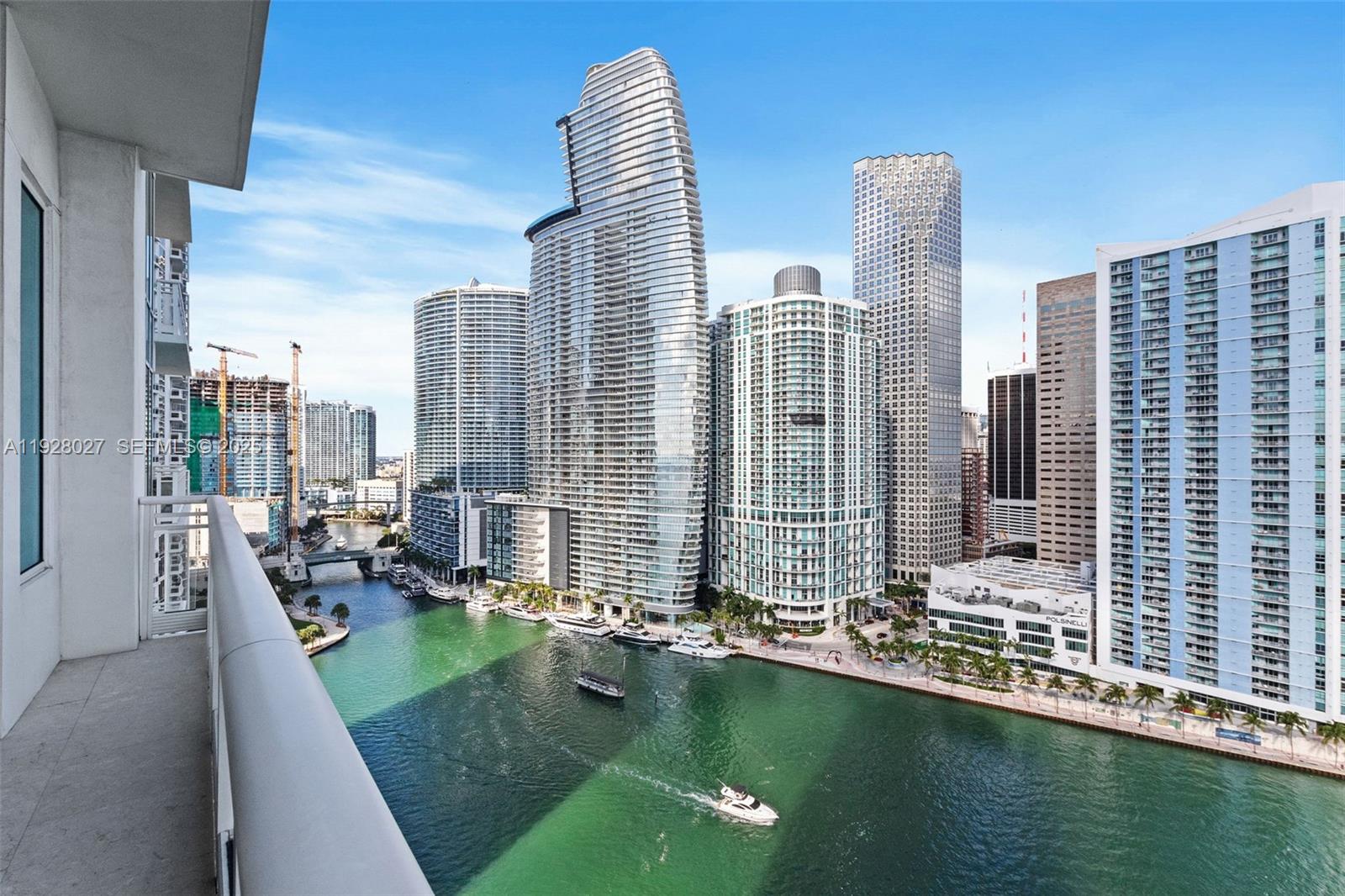 A high-angle view from a balcony overlooking a river and modern city skyscrapers — 900 Brickell Key Blvd # 2002, Miami FL 33131, MIAMI, FL