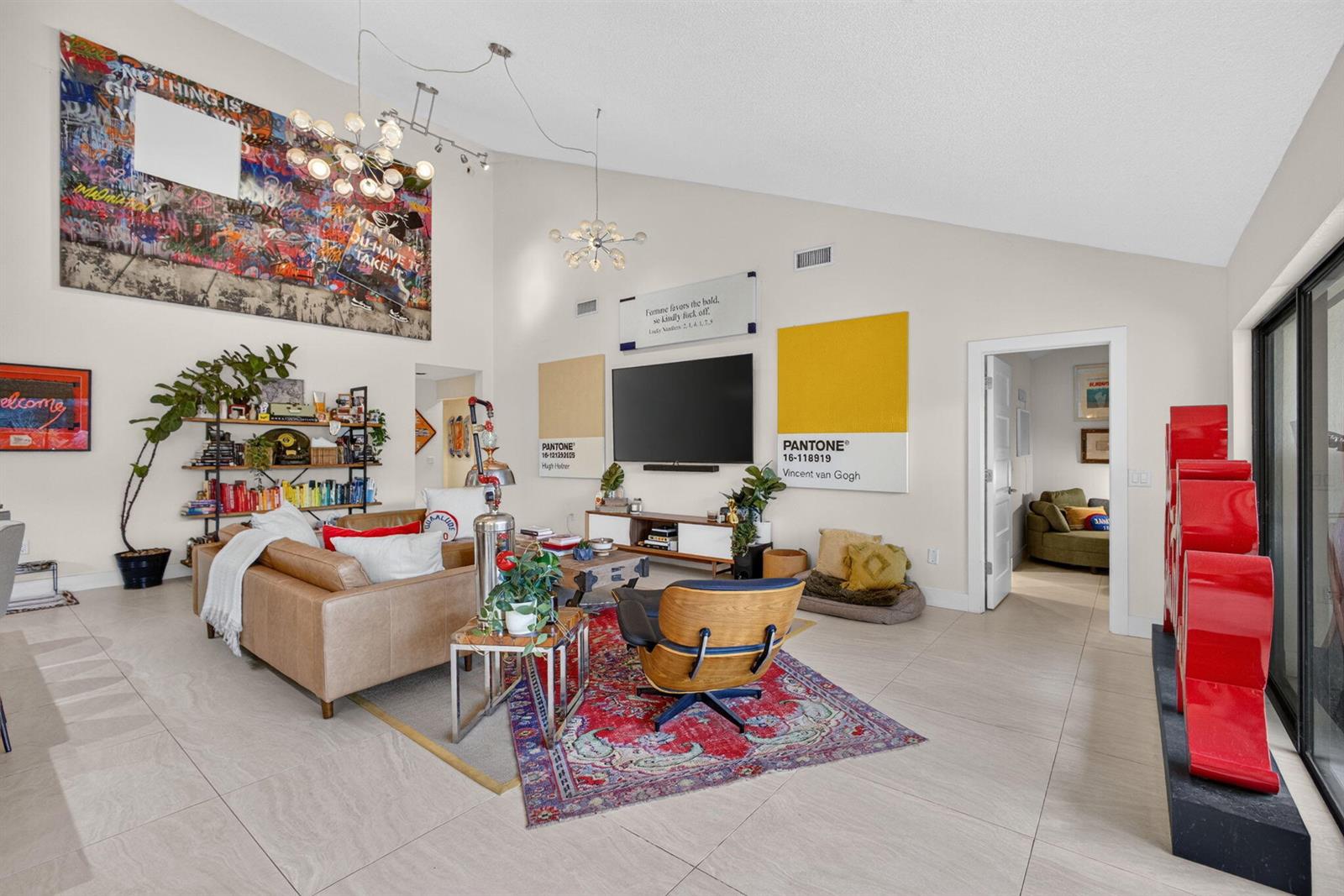 A living room features a vaulted ceiling, a large graffiti art piece, and a red rug — 2613 Mohawk Circle, West Palm Beach FL 33409, WEST PALM BEACH, FL
