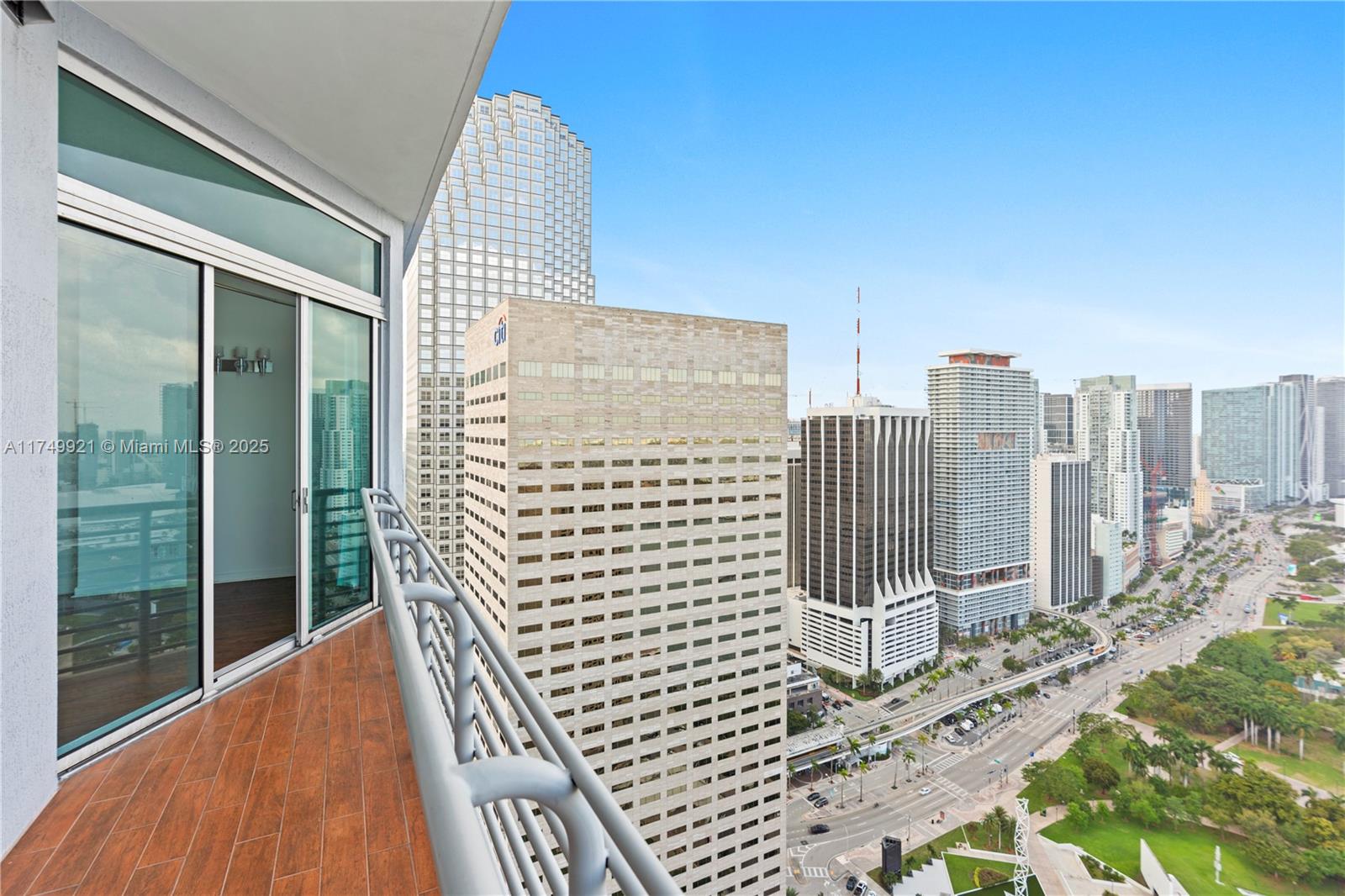 A balcony with wood-look tile flooring overlooks a dense city skyline and a park — 335 S Biscayne Blvd, Miami FL 33131, MIAMI, FL